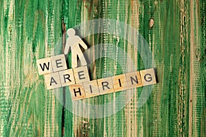 Wooden figure and wooden cubes with We Are Hiring letters
