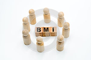 Wooden figures as business team in circle around acronym BMI Body Mass Index