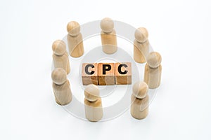 Wooden figures as business team in circle around acronym CPC Cost Per Click