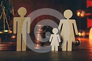 Wooden figures of family with child and gavel on a table close-up. Family law concept