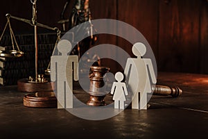 Wooden figures of family with child and gavel on a table. Divorce and alimony concept photo