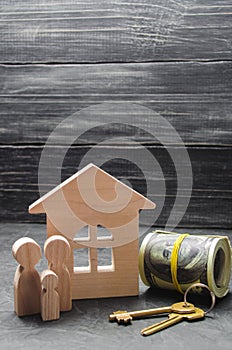 The wooden figures of the family stand near a wooden house, keys