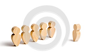 Wooden figures of people stand in the formation and listen to their leader. Business training, briefing and inspirational speech.