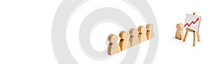 Wooden figures of people stand in the formation and listen to their leader. Business training, briefing and inspirational speech.