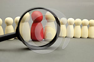 Wooden figures of people. Team leader under a magnifying glass, business concept photo