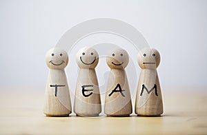 Wooden figures smile face with team wording on body for teamwork and business corporation concept