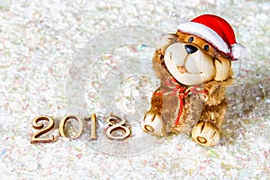 Wooden figures of 2018 on snow. Christmas atmosphere. The new year 2018. A toy dog is a symbol of the New Year.