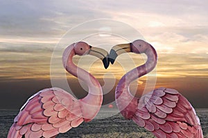 Wooden figurine of a pair of flamingos against a quaint sunset. Valentine.