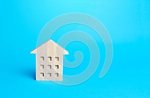 Wooden figurine of a residential building. Minimalism. Affordable housing. Rent of real estate. Construction industry. Realtor