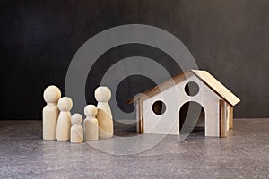 Wooden figurines of a family and a credit card near a white house