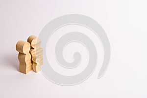 Wooden figurines of parents and a child on a white background. Minimalism The concept of the family and the upbringing of children