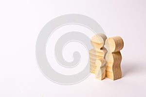 Wooden figurines of a young family on a white background. Concept of a young strong and healthy married couple.