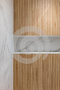 Wooden finishing in shower zone of modern refurbished bathroom.