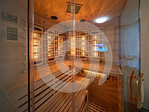 Wooden Finnish sauna in apartment. Glass door.