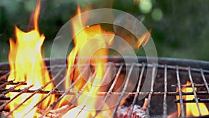 Wooden firewood and charcoal burn fire with hot orange flames, sparks and smoke in grill stove.