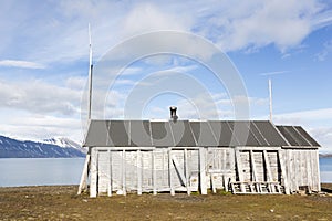 Wooden fisherman`s hut lies in a fjord in Spitzbergen