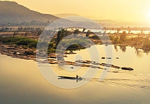 Wooden fishing boat sailing in mekong river on sunrise at border of thailand and laos