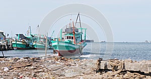 wooden fishing boat slides back into the sea, freshly restored in the boatyard at the water\'s edge