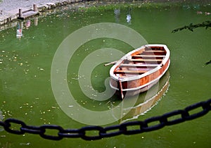 Wooden fishing boat in a still lake water