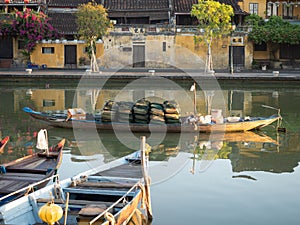 Wooden Fishing Boats in the Thu Bon River with Gold Stucco Buildings in the Background