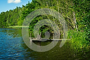 Wooden fishing jetty on a small forest lake