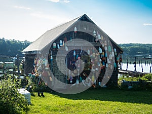 Wooden fishing shack decorated with lobster buoys on a sunny summer day