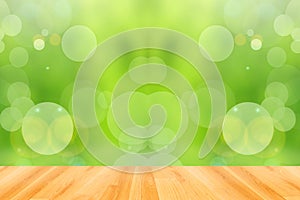 Wooden floor and abstract green bokeh background