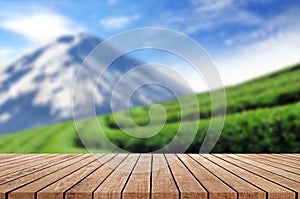 Wooden floor with blurred beautiful landscape of tea plantation