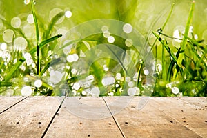 Wooden floor and bokeh background of grass leaves with dew sticks