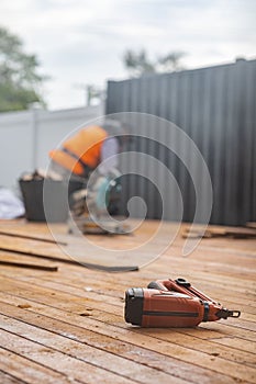 wooden floor with a electric sander and a man working in the background