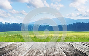 Wooden floor with Meadow with forest, mountain, blue sky and white clouds landscape in summer