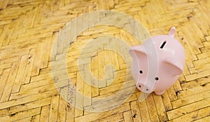 Wooden floor with a piggy bank  - copyspace for your individual text