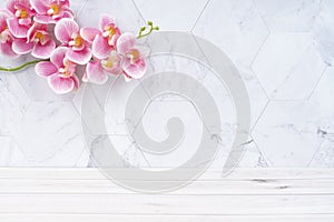 The Wooden floor and pink color orchid decorate on marble background, empty room for background