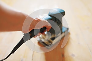 Wooden floor sanding with flat sander tool