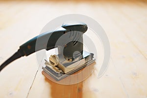 Wooden floor sanding with flat sander tool