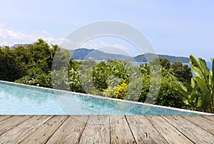 wooden floor with swimming pool overlooking view andaman sea mountains and blue sky background,summer holiday background concept.