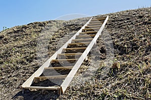 Wooden flooring lies on the hillside as a symbol of development, human movement