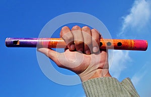 Wooden flute under calm sky in a hand