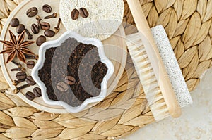 Wooden foot brush with pumice stone and homemade exfoliating foot scrub with ground coffee, star anise and clove. Natural pedicure