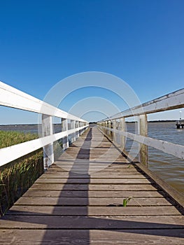 A wooden footbridge leads into the Bodden near Wieck a. Darss, Germany photo