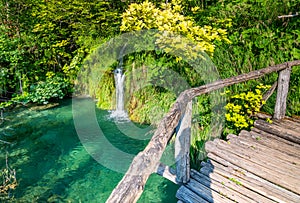 Wooden footpath at Plitvice national park, Croatia. Pathway in the forest near the lake and waterfall. Fresh beautiful nature,