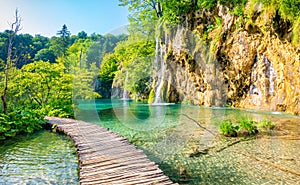 Wooden footpath at Plitvice national park, Croatia. Pathway in the forest near the lake and waterfall. Fresh beautiful nature,