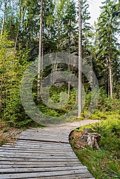 Wooden footpath with trees and rock formations around in CHKO Broumovsko in Czech republic