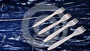 Wooden fork lying on a wooden table. Cutlery for eating. Device photo