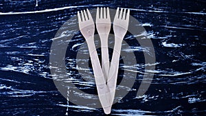 Wooden fork lying on a wooden table. Cutlery for eating. Device photo