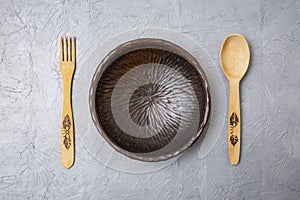 Wooden fork, spoon and sculpted bowl on acrylic gray cement