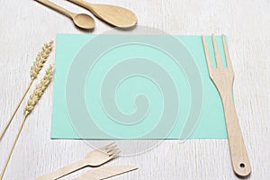 Wooden fork on turquoise sheet of paper