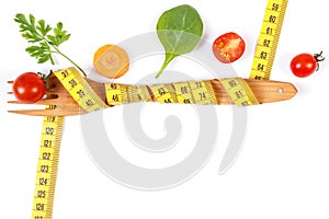 Wooden fork wrapped centimeter and fresh vegetables, concept of lose weight and healthy nutrition