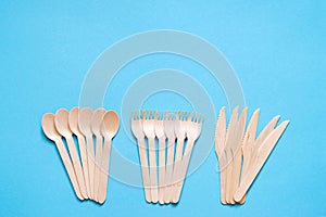 Wooden forks, spoons and knives on a blue background