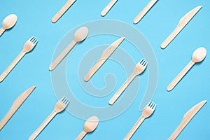 Wooden forks, spoons and knives on a blue background